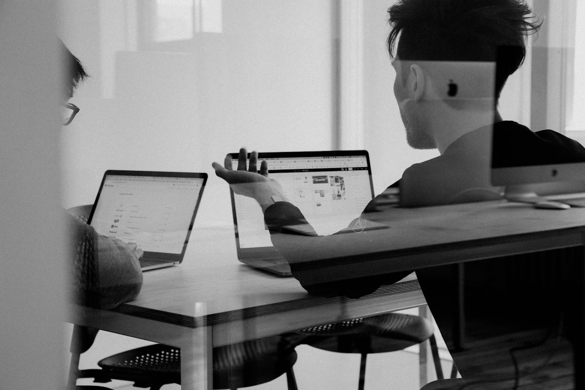 Indie hacker founder working at a desk with code editor and social media analytics on screen